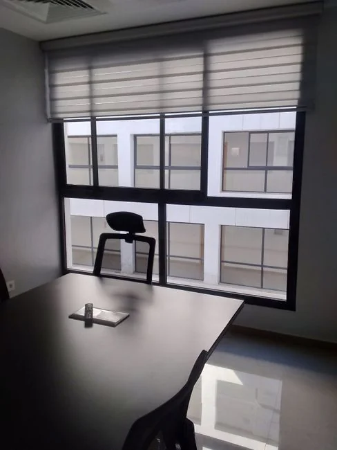 Intérieur élégant avec des cartons de déménagement étiquetés Kitchen et Office sur une table en bois, entourée de plantes d’intérieur.